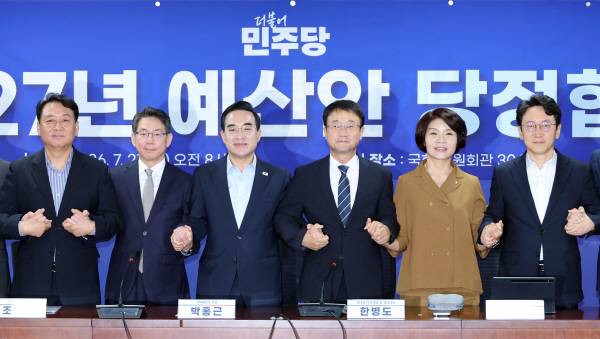 더불어민주당 한병도 직무대행 겸 원내대표(왼쪽 네 번째)와 박홍근 기획예산처 장관(왼쪽 세 번째)이 21일 국회 의원회관에서 열린 2027년 예산안 당정 협의에서 손을 잡고 기념 촬영을 하고 있다. 연합뉴스