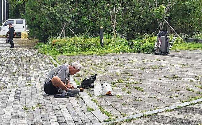 [수원=뉴시스] 최유리 인턴기자=한 노숙인이 맨바닥에 앉아 도시락을 먹는 모습.   *재판매 및 DB 금지