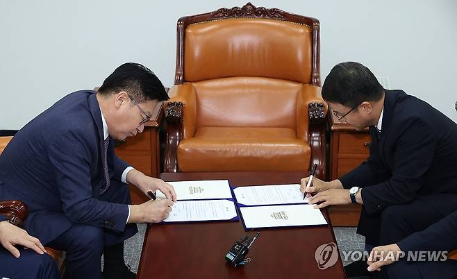 여야, 선관위 투표용지 부족 사태에 따른 특검 합의 (서울=연합뉴스) 배재만 기자 = 더불어민주당 한병도 대표 직무대행 겸 원내대표(오른쪽)와 국민의힘 정점식 원내대표가 21일 국회 운영위원장실에서 선관위 투표용지 부족 사태에 따른 특검법안 합의문에 서명하고 있다. 2026.7.21 [공동취재] scoop@yna.co.kr