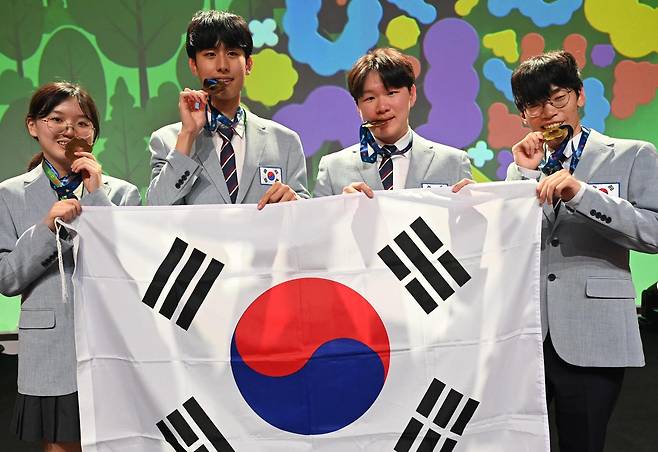 19일 제37회 국제생물올림피아드가 열린 리투아니아 빌뉴스에서 한국대표단 학생들이 금메달을 목에 걸고 태극기를 들어 보였다. 왼쪽부터 오지윤, 배준수, 김민재, 최재영 학생. 과학기술정보통신부 제공