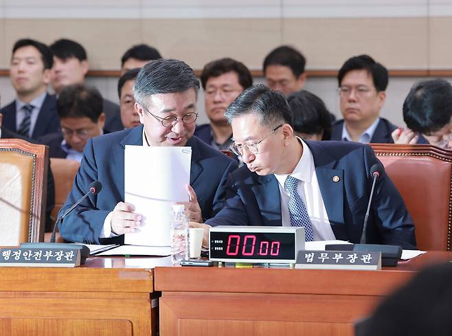 정성호 법무부 장관(오른쪽)과 윤호중 행정안전부 장관이 22일 국회에서 열린 법제사법위원회 전체회의에서 대화하고 있다. 연합뉴스