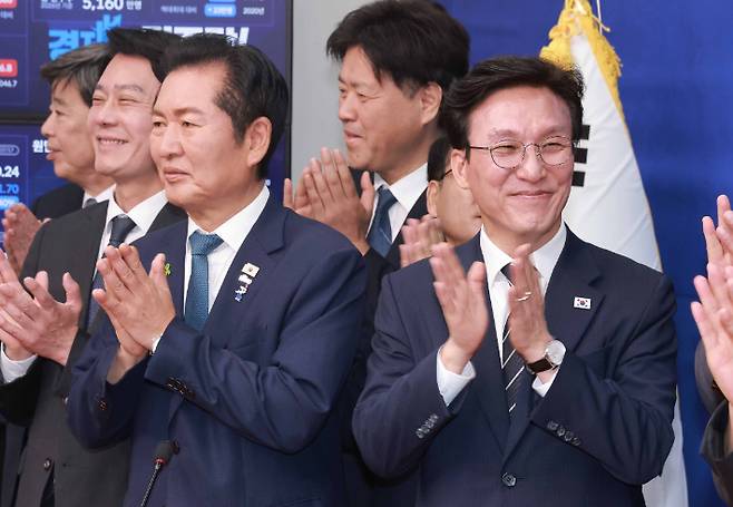 더불어민주당 8.17 전당대회에서 당 대표직에 출마하는 정청래 전 대표와 김민석 전 국무총리가 20일 국회에서 열린 공명선거 실천 서약식에 참석, 박수치고 있다. 연합뉴스