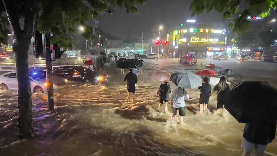 2022년 8월 8일 밤 서울 관악구 도림천이 범람, 시민들이 아슬아슬하게 물살을 헤쳐 길을 건너고 있는 모습. 뉴스1