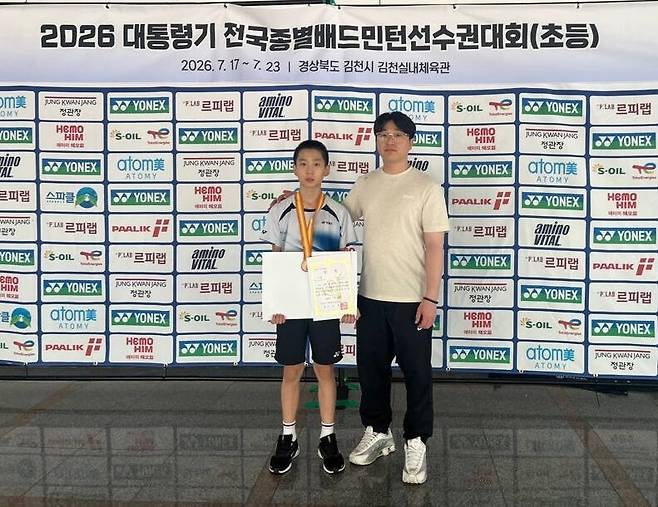 수원 태장초 진민준(왼쪽)이 23일 경북 김천시 김천실내체육관에서 막을 내린 ‘2026 대통령기 전국종별배드민턴선수권대회’에서 초등부 남자 단식에서 3위를 차지하고 장훈희 코치와 기념촬영을 하고 있다. 태장초 제공