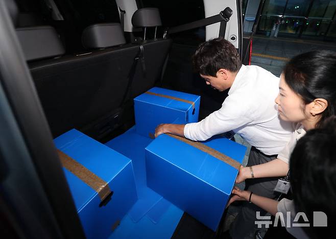 [과천=뉴시스] 김금보 기자 = 검경 합동수사본부 직원들이 23일 오후 경기 과천시 중앙선거관리위원회에서 압수수색을 마친 뒤 압수품을 차량에 싣고 있다.합동수사본부는 6·3 지방선거 당일 벌어진 투표율 허위 조작 입력과 투표 용지 부족으로 인한 국민참정권 침해와 관련해 중앙선거관리위원회, 경기도선거관리위원회, 서울 송파구선거관리위원회에 대한 압수수색을 했다. 2026.07.23. kgb@newsis.com