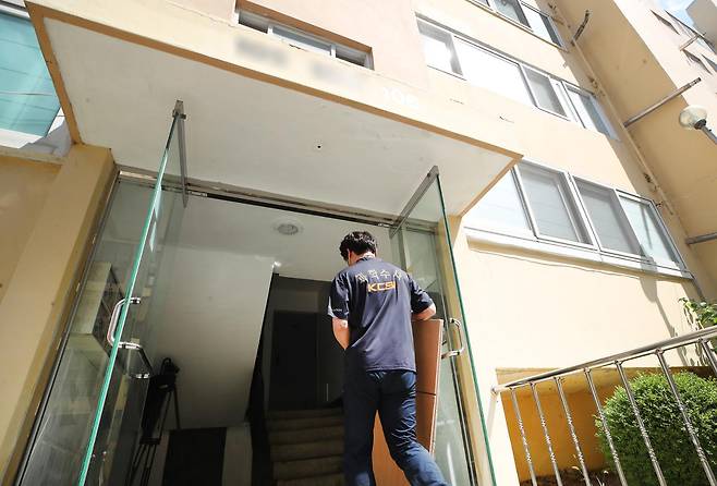 경북 경산시 한 아파트 관리사무소 방화사건을 수사하는 경북경찰청 관계자가 24일 70대 방화 피의자 유모씨의 주거지에 대한 압수수색을 위해 집으로 들어가고 있다. 경산=뉴스1
