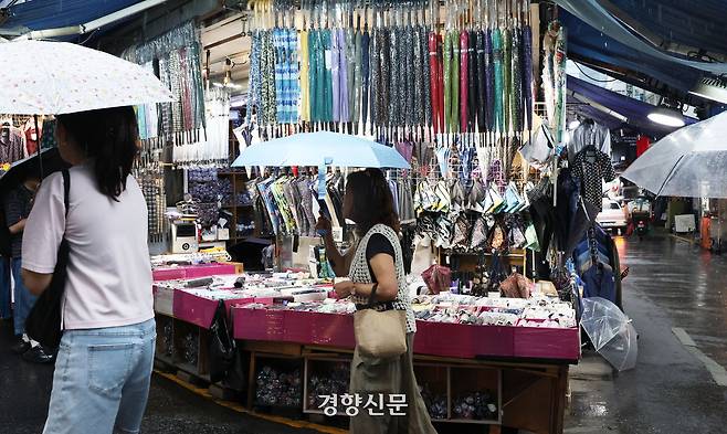 서울 중구 남대문시장 한 우산 가게 앞을 우산 쓴 시민들이 지나가고 있다. 한수빈 기자