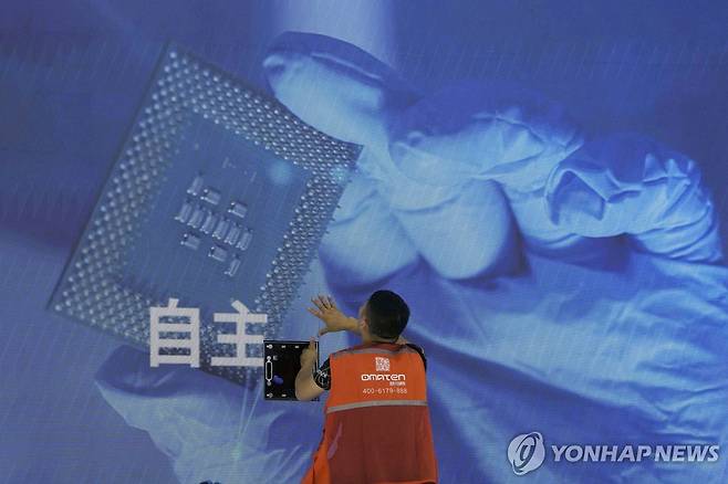 2023년 상하이 WAIC에서 한 관계자가 '자주'가 적힌 광고 패널을 부착하는 모습 [AP=연합뉴스 자료사진. 재판매 및 DB 금지]