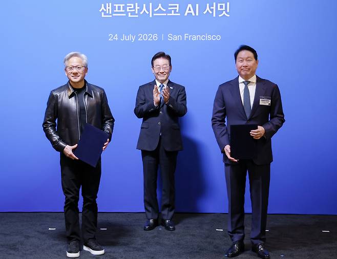 최태원 SK 회장과 젠슨 황 엔비디아 최고경영자가 24일(현지시간) 이재명 대통령이 임석한 가운데 미국 샌프란시스코 더 미드웨이에서 열린 AI 서밋에서 SK하이닉스, SKT와 엔비디아의 전략적 AI 팩토리 및 반도체 협력 MOU를 체결한 뒤 기념촬영을 하고 있다. [연합]