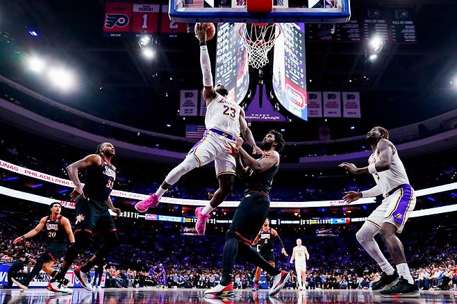 FILE - Los Angeles Lakers' LeBron James, center left, goes up for the shot against Philadelphia 76ers' Joel Embiid, center right, during the second half of an NBA basketball game, Dec. 7, 2025, in Philadelphia. (AP Photo/Chris Szagola, File) FILE PHOTO        <저작권자(c) 연합뉴스, 무단 전재-재배포, AI 학습 및 활용 금지>