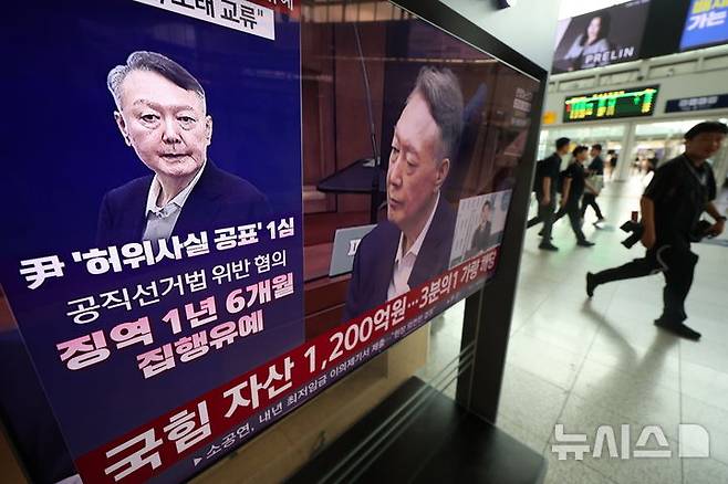 [서울=뉴시스] 김명년 기자 = 대선후보 시절 건진법사 전성배 씨에 관한 허위사실을 공표한 혐의로 기소된 윤석열 전 대통령 1심 선고 공판이 열린 27일 서울역에서 시민들이 관련 방송을 지켜보고 있다. 이날 재판부는 윤 전 대통령에게 징역 1년 6개월에 집행유예 3년을 선고했다. 2026.07.27. kmn@newsis.com