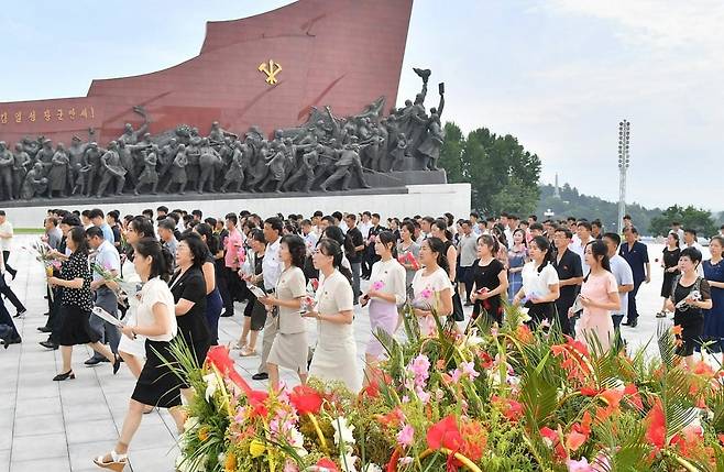 북한 노동당 기관지 노동신문은 28일 '전승절' 73주년을 맞아 일꾼(간부)과 근로자, 인민군 장병, 청소년·학생들이 각지의 김일성·김정일 동상을 찾아 꽃바구니를 진정했다고 보도했다. 사진은 평양 만수대언덕에서 주민들이 꽃을 들고 김일성·김정일 동상으로 향하는 모습. /노동신문·뉴스1