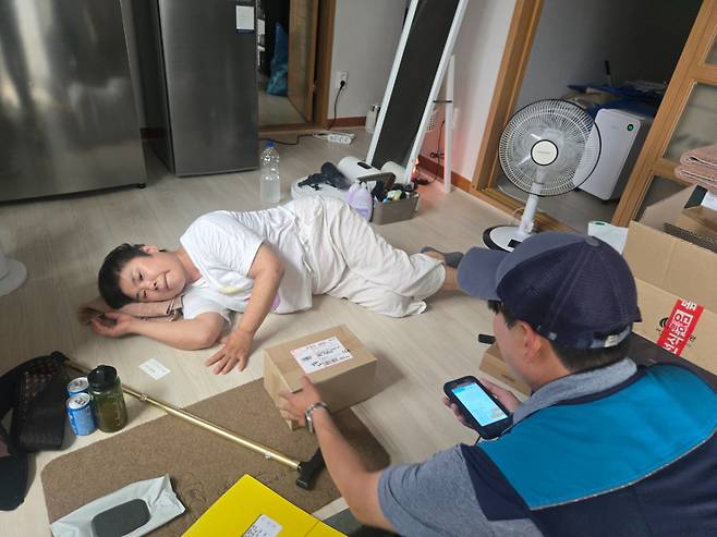 신은철 집배원이 23일 김경빈(61세)씨에게 '안부살핌 소포'를 전달하고 있다./사진=이찬종 기자
