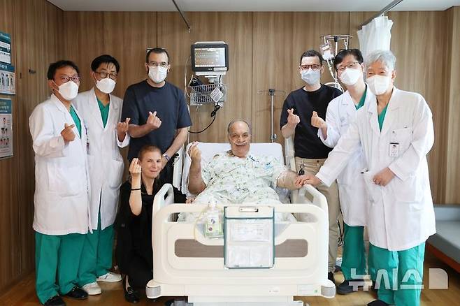 [서울=뉴시스] 모로코 삼부자 가족이 2대1 생체간이식 수술을 집도한 서울아산병원 간이식·간담도외과 의료진과 기념촬영을 하고 있다. 왼쪽 첫 번째부터 문덕복·송기원 교수, 기증자인 첫째 아들 하침씨, 수혜자의 아내, 수혜자 모하메드씨, 기증자인 둘째 아들 오마르씨, 정동환 교수·이승규 석좌교수.  (사진= 서울아산병원 제공)