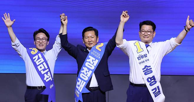 더불어민주당 당권 주자인 김민석(왼쪽부터), 정청래, 송영길 의원이 1일 대전 유성구 대전컨벤션센터에서 열린 당대표·최고위원 합동연설회에서 손을 맞잡고 만세하고 있다. [뉴스1]