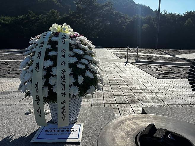 김용민 민주당 의원이 지난 1일 경남 김해 봉하마을을 찾아 노 전 대통령 묘역에 전날 국회 본회의에서 처리된 형사소송법 개정안이 담긴 서류 봉투를 올려놓았다. 그 옆 조화에는 김 의원의 이름과 함께 '내주신 숙제 끝냈습니다. 대통령님'이라는 문구가 적혀있다.