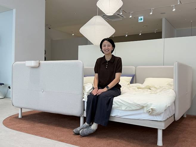 김지현 일룸 총괄팀장이 패밀리 침대 ‘쿠시노’ 위에 앉아 있다. /일룸