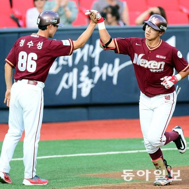데뷔 첫 홈런을 쏘아 올린 뒤 정수성 당시 코치(왼쪽)와 인사를 나누는 김웅빈. 동아일보DB