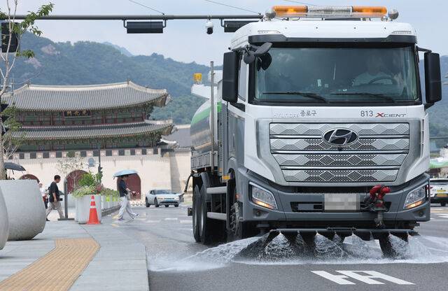 서울에 첫 '폭염중대경보'가 발령된 4일 서울 시내에서 종로구 도로 물청소차 작업자가 아스팔트를 식히는 살수 작업을 하고 있다. 연합뉴스