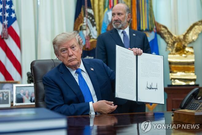 행정명령에 서명한 트럼프 미국 대통령 6일(현지시간) 미국 워싱턴 D.C.에 위치한 백악관 집무실서 트럼프 미국 대통령이 서명한 행정명령을 공개하고 있다. [EPA=연합뉴스. 재판매 및 DB 금지]