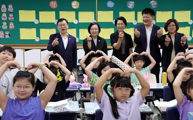 7일 한성숙(맨 뒷줄 왼쪽 두 번째) 국무총리가 방학 중 초등돌봄·교육 현장인 서울 영등포구 영문초등학교를 방문해 팝업북만들기 교실을 참관한 뒤 학생들과 기념촬영하고 있다. 뉴시스
