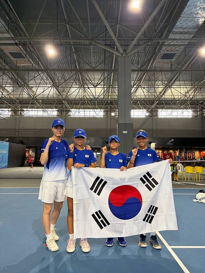 김지영 감독이 12세 이하 어린 꿈나무 대표 선수들과 태극기를 들어 보이고 있습니다. 대한테니스협회 제공