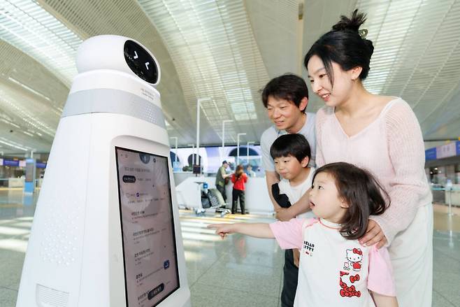 인천국제공항 제2여객터미널 3층 출국장에서 여객들이 신규 안내·순찰 로봇을 이용해 공항 정보를 확인하고 있다. 공항공사 제공
