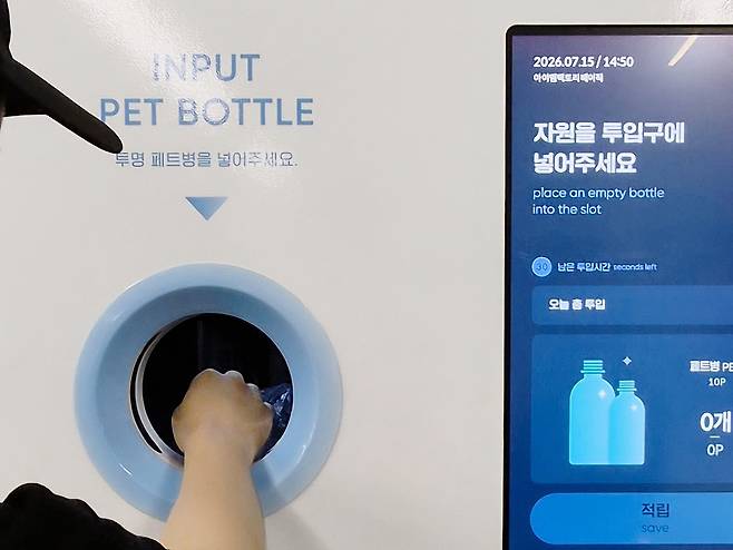 기아챌린지 ECO 서포터즈 ‘그린T’팀 부원이 수퍼빈의 AI 순환자원 회수로봇 ‘네프론’에 투명 페트병을 투입하고 있다. 그린T팀 제공