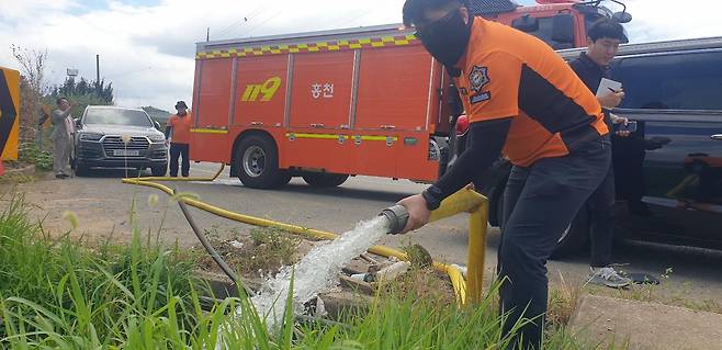 12일 경남 밀양시 부북면 청운리 들녘에서 홍천소방서 소방대원들이 극심한 가뭄으로 말라가는 논에 소방 호스로 비상 급수를 하고 있다. 밀양=이동렬 기자