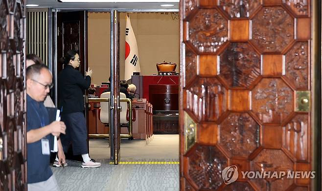 더불어민주당 비공개 의원총회 (서울=연합뉴스) 이동해 기자 = 13일 국회에서 더불어민주당 비공개 의원총회가 열린 가운데 관계자들이 회의실 문을 닫고 있다. 2026.8.13 eastsea@yna.co.kr