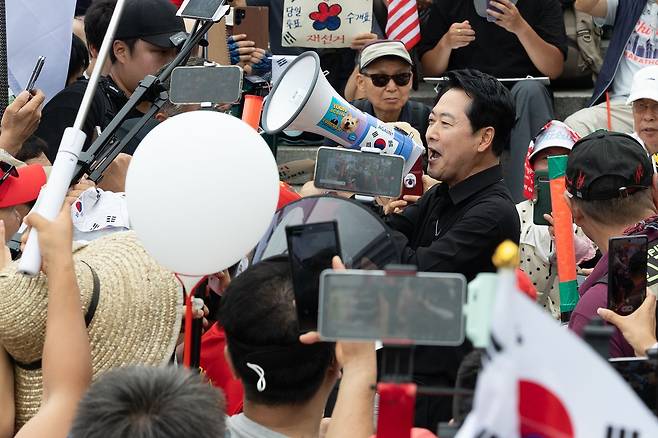 장동혁 국민의힘 대표가 7월 17일 오후 서울 송파구 올림픽공원 핸드볼경기장 앞 시위 현장을 찾아 확성기로 구호를 외치고 있다. 뉴스1