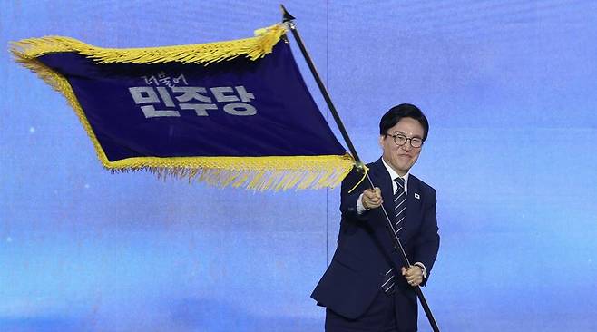 더불어민주당 김민석 신임 당 대표가 17일 대전 컨벤션센터에서 열린 제3회 더불어민주당 정기 전국당원대회에서 당 대표로 선출된 뒤 당기를 흔들어 보이고 있다. 연합뉴스