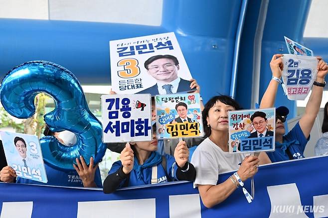 더불어민주당 지지자들이 17일 대전컨벤션센터에서 열린 전국당원대회에서 김민석 당대표 후보와 김용·서미화 최고위원 후보의 피켓을 들고 응원하고 있다. 임은재 기자
