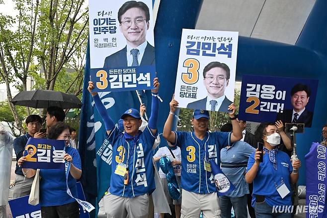 더불어민주당 지지자들이 17일 대전컨벤션센터 앞에서 김민석 당대표 후보와 김용 최고위원 후보의 피켓을 들고 응원하고 있다. 임은재 기자
