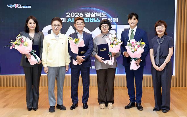 ▲ 18일 도청 다목적홀에서 시·군 관계자와 영상제 조직위원 등 100여 명이 참석한 가운데 '2026 경북 국제 AI·메타버스 영상제(GAMFF 2026)'의 주요 프로그램과 발전 전략을 발표 하기전 영상제 조직위원 위촉식을 기졌다. 이날 영상제 집행위원장에 양경미 한국영상콘텐츠학회 회장(사진왼쪽),이철우도지사,영상제 조직위원장에 김세연 세이버파트너스 대표이사,영상제 고문에 식음연구소 대표이자 브랜드 컨설턴트인 노희영 대표이사,대외협력위원장에 드라마 '주몽', '강남스캔들' 등에 출연한 원기준 배우, 양금희 행정부지사가 기념촬영을 하는 장면, 경북도제공