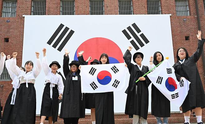 광복절을 하루 앞둔 14일 충남 천안시 성정청소년문화의집 청소년 역사 여행 '호국영웅투어'에 참가한 학생들이 서울 서대문구 서대문형무소역사관을 찾아 독립운동가 복장으로 태극기 앞에서 '대한독립만세'를 외치고 있다. 왕태석 선임기자