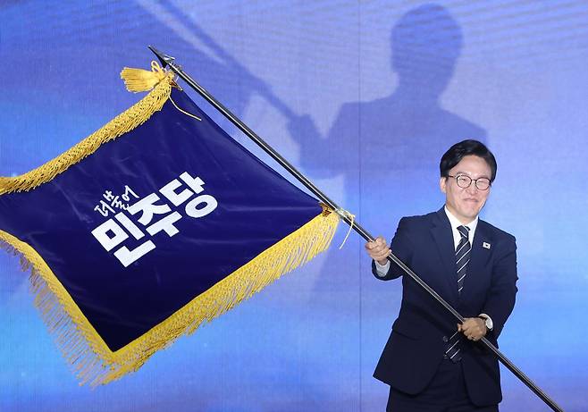 김민석 더불어민주당 신임 대표가 17일 대전 컨벤션센터에서 열린 제3회 더불어민주당 정기 전국당원대회에서 당대표 당선을 확정한 뒤 당기를 흔들고 있다. 대전=연합뉴스