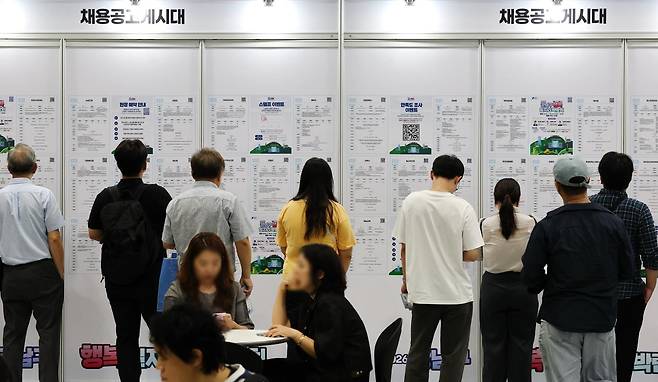 지난달 15일 서울 강남구 코엑스에서 열린 '2026 강남구 행복 일자리 박람회'를 찾은 구직자들이 채용공고를 살펴보고 있다. 연합뉴스