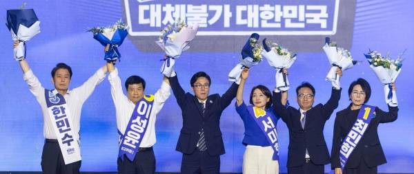 ▲2026년 8월 17일 더불어민주당 당대표에 선출된 김민석 전 총리와 최고위원 당선인들이 대전 컨벤션센터에서 열린 제3회 더불어민주당 정기 전국당원대회에서 당원들과 국민들을 향해 인사하고 있다. 왼쪽부터 한민수 최고위원, 이성윤 최고위원, 김민석 신임 당 대표, 서미화 최고위원, 박선원 최고위원, 최민희 수석최고위원. ⓒ연합뉴스
