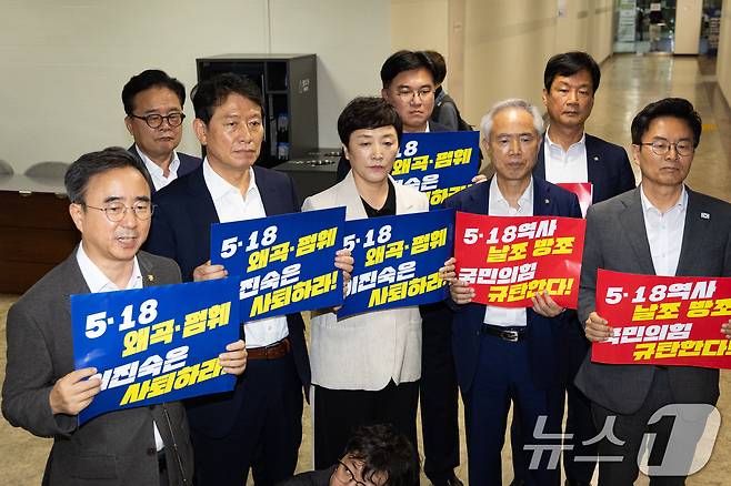 더불어민주당 의원들이 13일 서울 여의도 국회도서관에서 열린 '5.18 민주화운동의 재조명' 국회공개포럼 행사장 앞에서 포럼을 주최한 이진숙 국민의힘 의원을 규탄하고 있다. 2026.8.13 ⓒ 뉴스1 유승관 기자