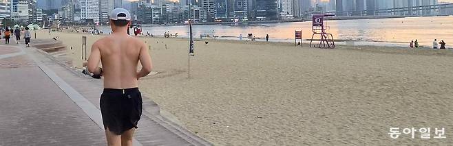 13일 오전 부산 수영구 광안리해수욕장에서 상의를 벗은 남성이 달리기를 하고 있다. 여름철 도심과 해변에서 이른바 ‘상탈 러닝족’이 늘면서 공공장소의 적절한 복장을 둘러싼 논란도 이어지고 있다. 김화영 기자 run@donga.com
