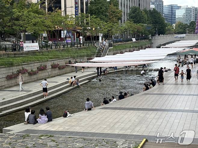 절기상 더위가 그친다는 처서(處暑)인 23일 오후 서울 종로구 청계천을 찾은 시민들이 대형 그늘막 아래에서 더위를 식히고 있다. 2026.8.23/뉴스1 ⓒ 뉴스1 소봄이 기자