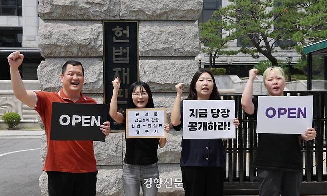 김정희원 미국 애리조나대 교수(왼쪽에서 두 번째)와 투명사회를위한 정보공개센터 활동가들이 2025년 6월13일 서울 종로구 헌법재판소 앞에서 판결문 접근성에 관한 헌법소원청구에 앞서 구호를 외치고 있다. 왼쪽부터 강성국 정보공개센터 활동가, 김정희원 교수, 정보공개센터 조민지 사무국장·이리예 활동가. 강윤중 기자