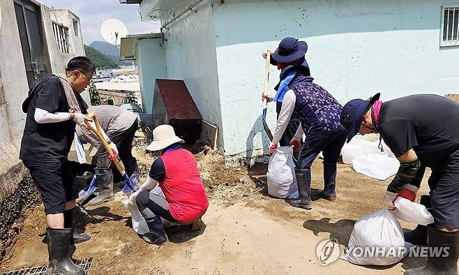 통영 곤리도 수해복구 나선 자원봉사자들 지난 22일 경남 통영시 산양읍 곤리도에서 대구 재난현장 통합자원봉사지원단 자원봉사자들이 집중호우로 주택 주변에 쌓인 토사를 삽으로 퍼내 자루에 담고 있다. [대구시자원봉사센터 제공. 재판매 및 DB 금지]