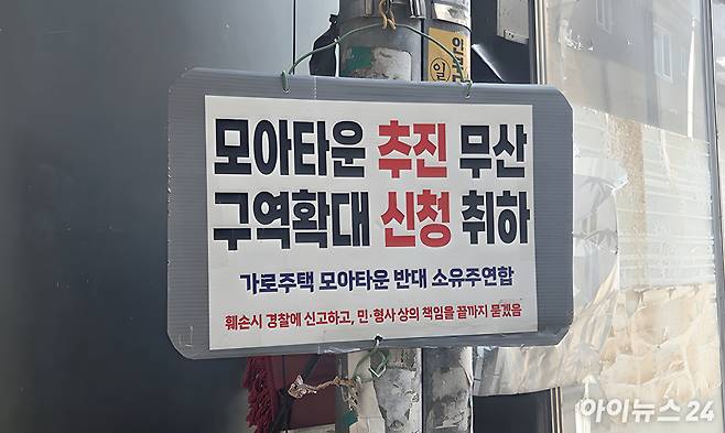 24일 서울 광진구 자양동 모아타운 사업지 내 건물 외벽에 사업 추진에 반대하는 내용의 팻말이 걸려있다. [사진=김민지 기자]