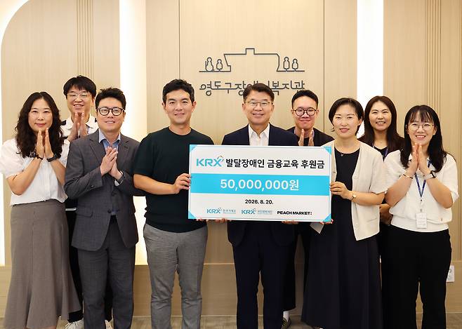 함의영(앞줄 왼쪽 세 번째부터) 피치마켓 대표와 정상호 한국거래소 국민행복단장 사무국장, 박기영 영도구장애인복지관 관장이 20일 열린 후원금 전달식에서 기념촬영을 하고 있다.  [한국거래소 제공]