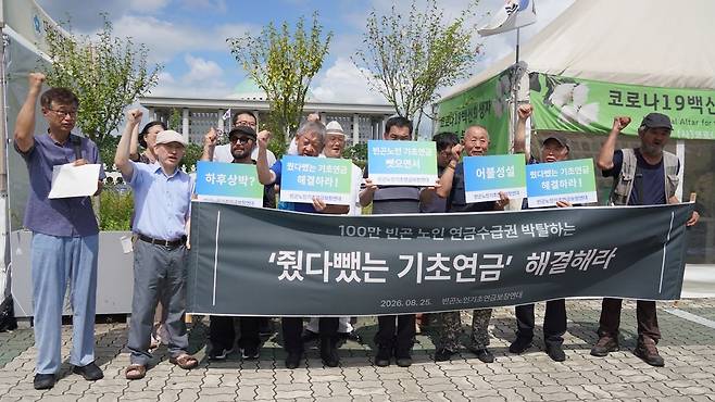 25일 기초생활 수급노인들과 복지시민단체 회원들이 국회 앞에서 ‘줬다뺏는 기초연금 해결하라’ 기자회견을 진행했다. 사진 빈곤노인기초연금보장연대