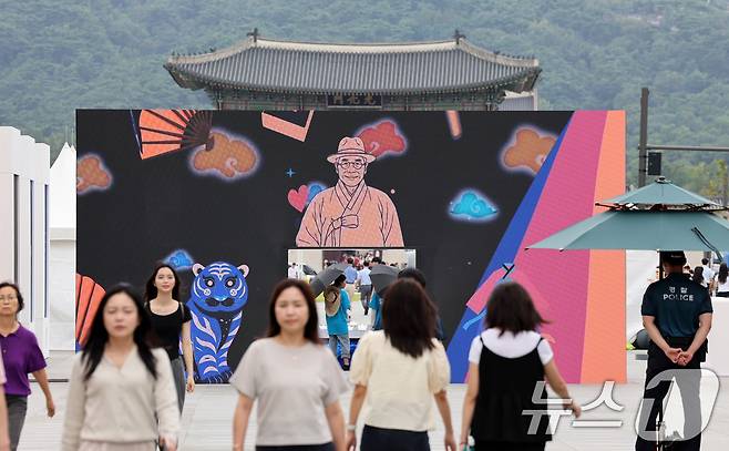26일 서울 종로구 광화문 광장에서 관광객들이 ‘김구 탄생 150주년'' 미디어 게이트를 통과하고 있다. 국가보훈부(장관 권오을)는 광복회(회장 이종찬)와 함께 ''김구 탄생 150주년 유네스코 기념해''를 맞아 30일까지 서울 광화문광장에서 국민 참여형 ‘김구 문화주간’ 행사를 개최한다고 밝혔다. 2026.8.26 ⓒ 뉴스1 이종덕 기자