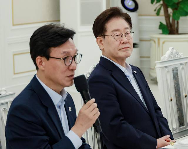 이재명 대통령이 지난 8월 25일 청와대에서 열린 더불어민주당 신임 지도부 만찬 간담회에서 김민석(왼쪽) 민주당 당대표의 발언을 듣고 있다. [연합뉴스]