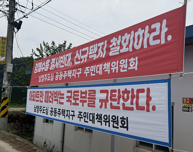 19일 오후 경기 남양주시 와부읍 도곡1리 마을회관 앞에 붙은 현수막 모습. 신규 택지 개발 계획을 발표한 정부를 규탄하는 내용이 적혀 있다. 최은서 기자